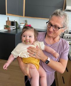 an older woman holding a baby in her arms