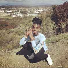 a young man sitting on top of a hill