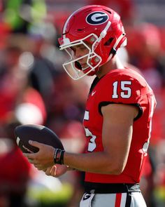 a close up of a football player holding a ball