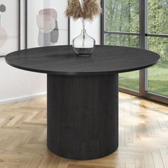 a black round dining table in an empty room