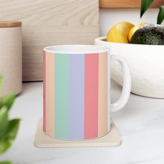 a coffee mug sitting on top of a counter next to a bowl of lemons