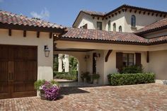 a house with two garage doors and brick driveway