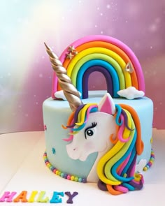 a birthday cake with a rainbow unicorn on top