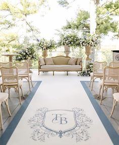 an outdoor ceremony setup with chairs, couches and flowers on the aisle for guests to sit down