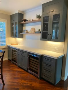 a kitchen with wooden floors and gray cabinets