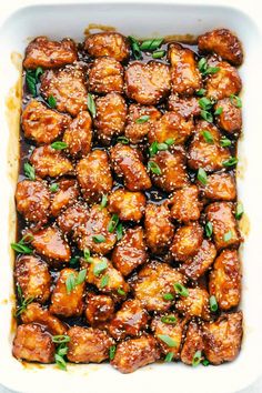 chicken with sauce in a casserole dish on a white table top, ready to be eaten