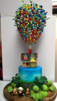 there is a cake that has been decorated like a house and hot air balloon on it