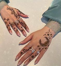 two hands with henna designs on them