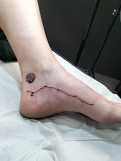 a person's foot with a small tattoo on the side of their left leg