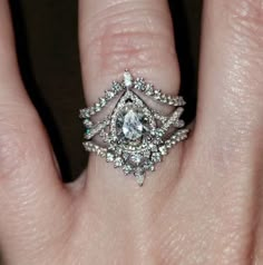 a woman's hand with a diamond ring on top of her finger and an engagement ring in the middle