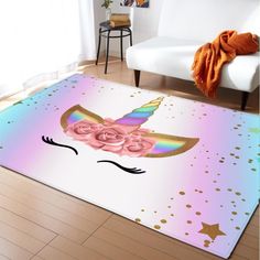 a rug with a unicorn face and pink roses on the floor in front of a white couch