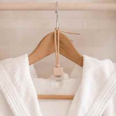 a white robe hanging on a wooden hanger