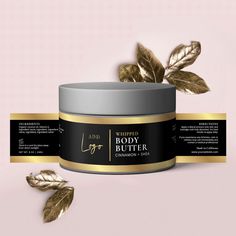 a jar of whipped body butter next to a gold leaf on a pink background with the label