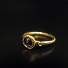 a gold ring with a black diamond on it