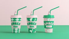 three starbucks cups with green straws and the words space kuu on them are stacked next to each other