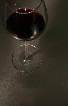 a glass of wine sitting on top of a table