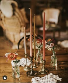 a table topped with candles and vases filled with flowers