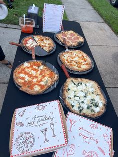 several pizzas are sitting on the table ready to be served at an outdoor party