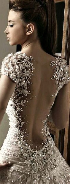 the back of a woman's wedding dress with beading and sequins