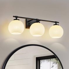 three light bathroom vanity fixture with white glass globe shades and black metal frame, shown from the front view