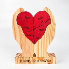 a wooden heart shaped puzzle with the words'together forever'on it and two pieces missing