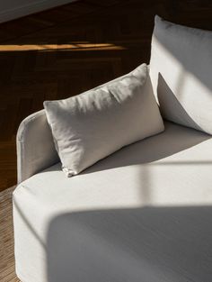 a white couch sitting on top of a hard wood floor