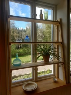 a window sill with plants and vases on it