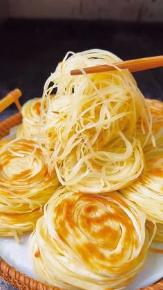 some noodles are on a plate with chopsticks