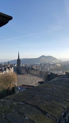 a view of a city from the top of a building with mountains in the background