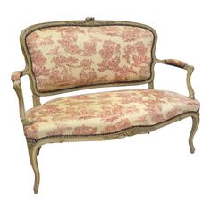 an old fashioned couch with floral fabric on it's back and armrests