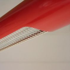 a close up view of the side of a red object that is hanging from a ceiling