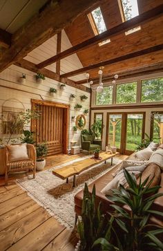 a living room filled with lots of furniture and plants on top of wooden flooring