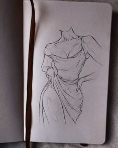 a drawing of a woman's dress on top of a book with a pencil