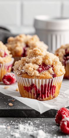 raspberry crumb muffins with powdered sugar and fresh berries on the side