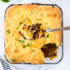 a spoonful of cornbread casserole on a plate with a fork in it