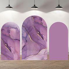 purple and gold art work displayed in an empty room with two arches on the floor