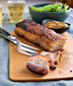 a wooden cutting board topped with meat and vegetables