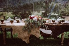 the table is set with flowers, candles and other items for an outdoor wedding reception