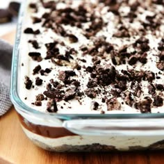 a glass dish filled with ice cream and chocolate chips on top of a wooden cutting board