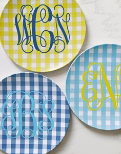 three plates with monogrammed designs on them, one is blue and the other has yellow