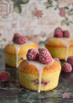 raspberry muffins with icing drizzled over them on a table