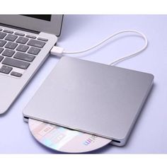 a laptop computer sitting on top of a white table next to a cd and mouse