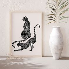 a black and white print of a cheetah on a wall next to a vase