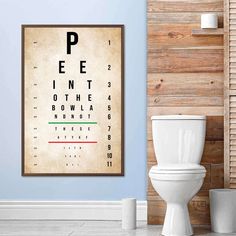 a bathroom with a toilet and eye chart on the wall