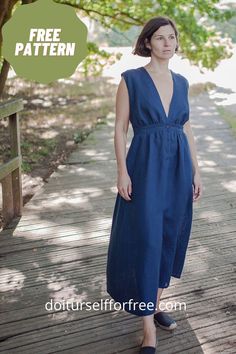 a woman standing on a wooden walkway wearing a blue dress