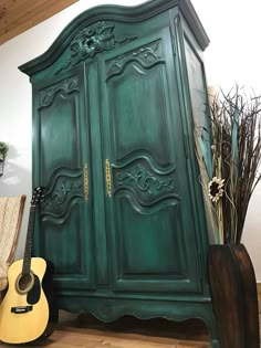 a green armoire sitting next to a guitar