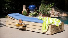 a blue and yellow towel sitting on top of a wooden bench next to a pool