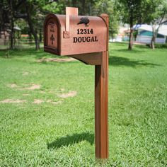 a mailbox in the grass with a crow on it's back and address