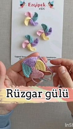 a person is holding some crocheted flowers in front of a card with the words ruzzar giuli on it