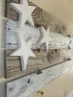 three white wooden stars hanging on a wall